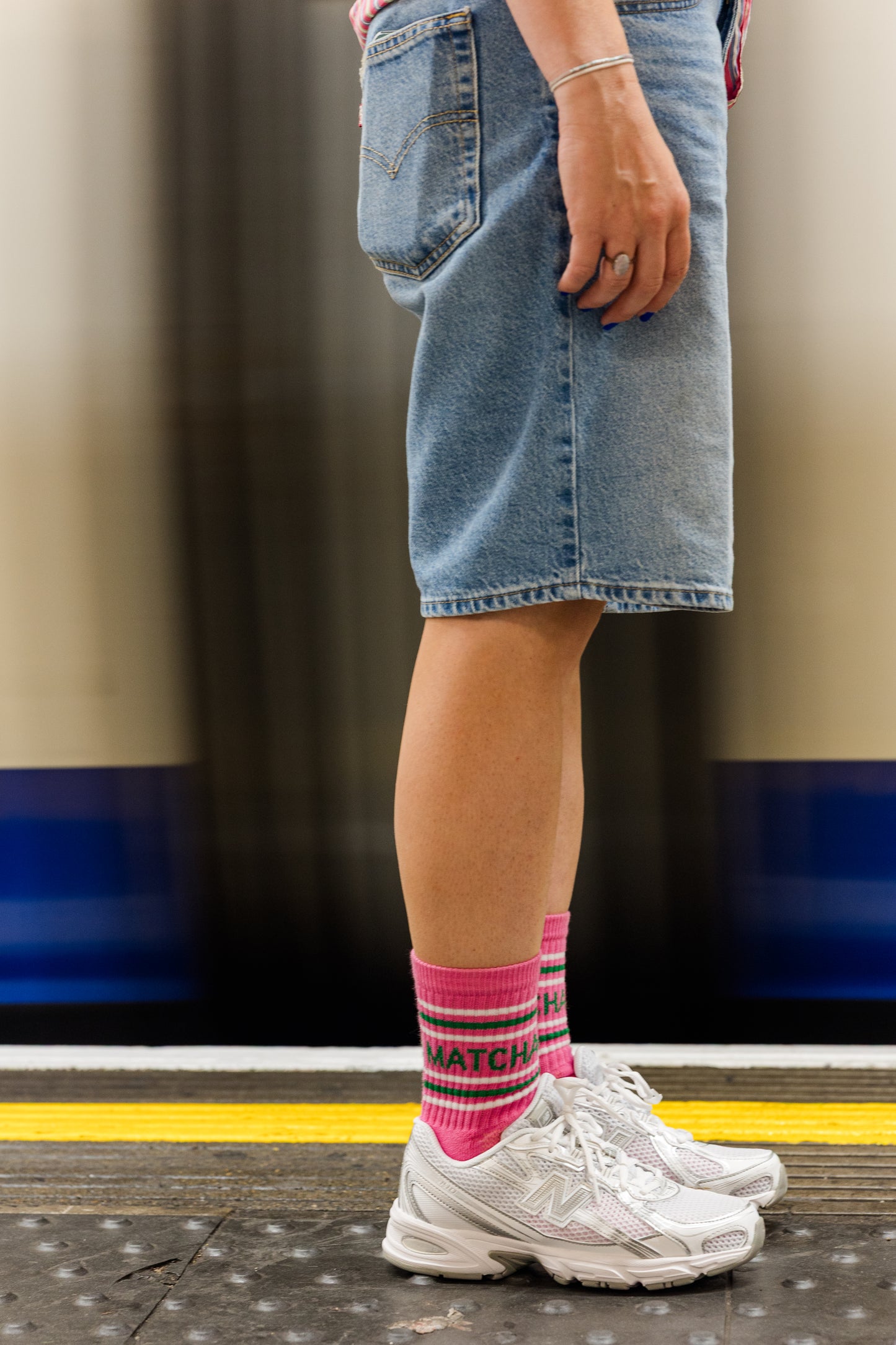 lady standing by the tube wearing matcha pink sports socks