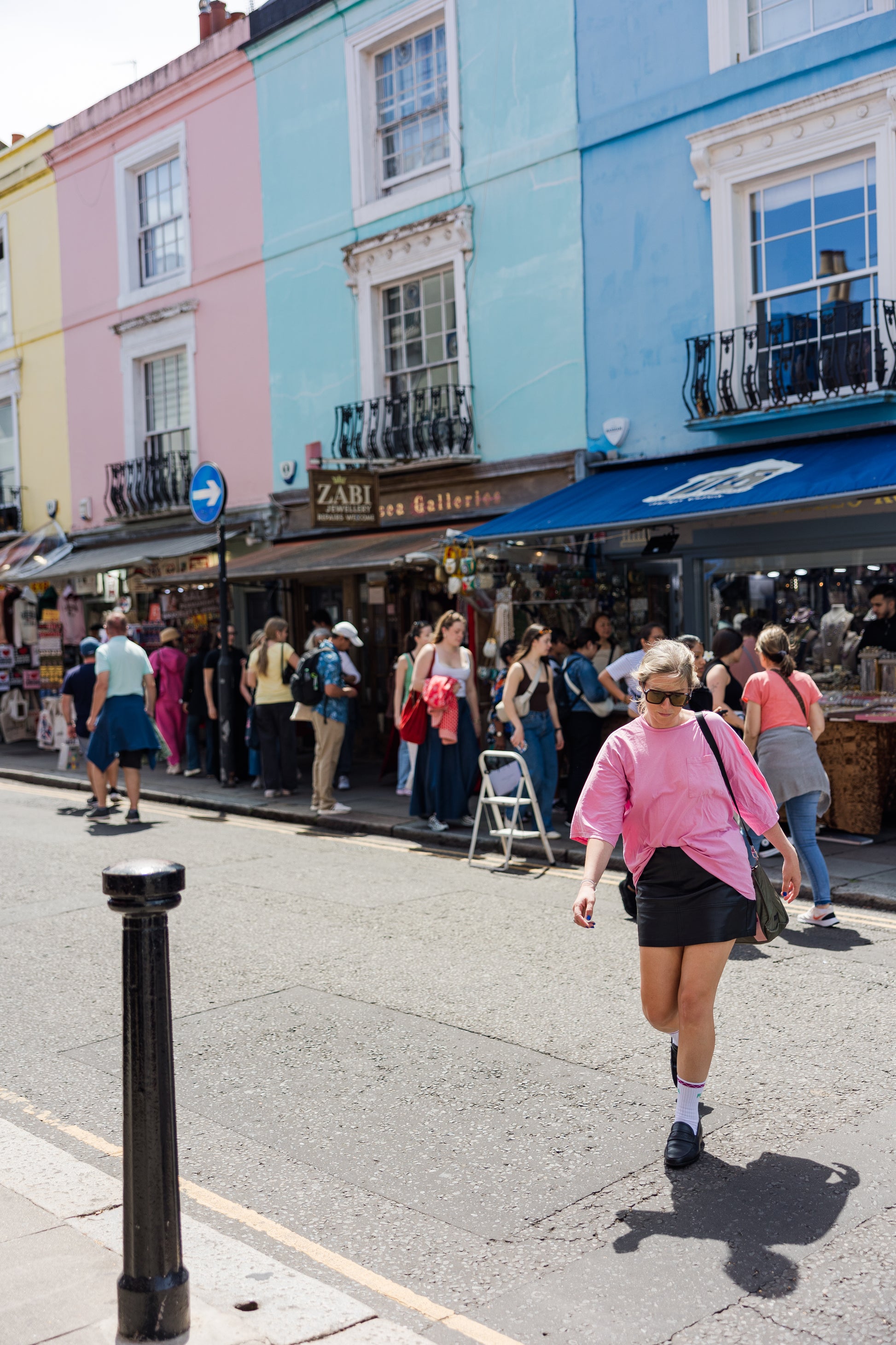 Lady walking across portobello road in wearing sports socks and loafers