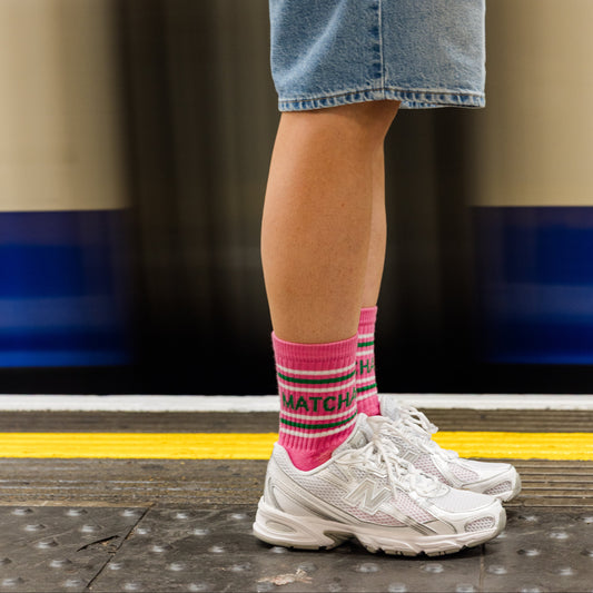 lady standing by the tube wearing matcha pink sports socks 